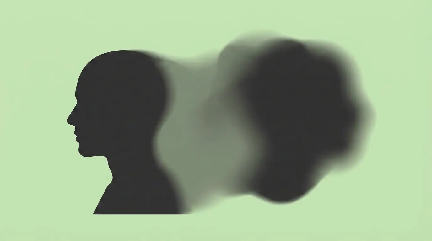 Dark silhouette of a human head in profile on the left side facing right, with a blurred, abstract shadow shape extending to the right against a pale beige background